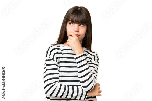 Little caucasian girl over isolated background having doubts and with confuse face expression