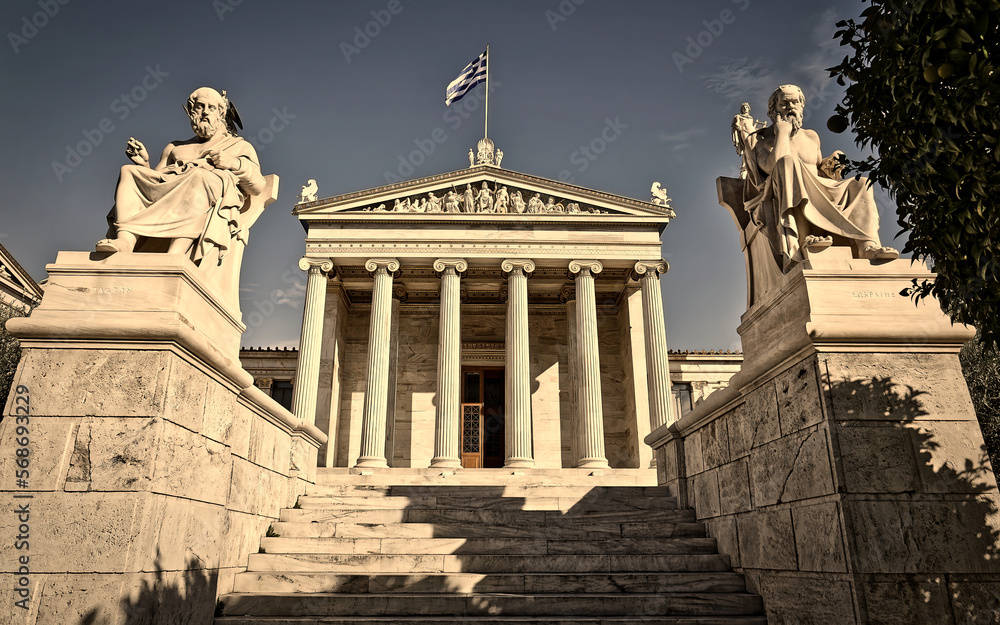 Obraz premium Plato and Socrates marble statues in front of the national university of Athens neoclassical building. Cultural travel In Greece.
