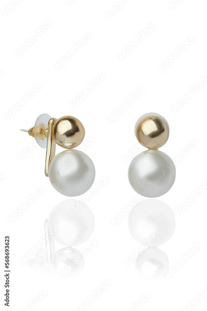 Subject shot of  stud earrings in the form of two beads. One of them is a pearl and the other is metallic. The earrings are isolated on a white background.