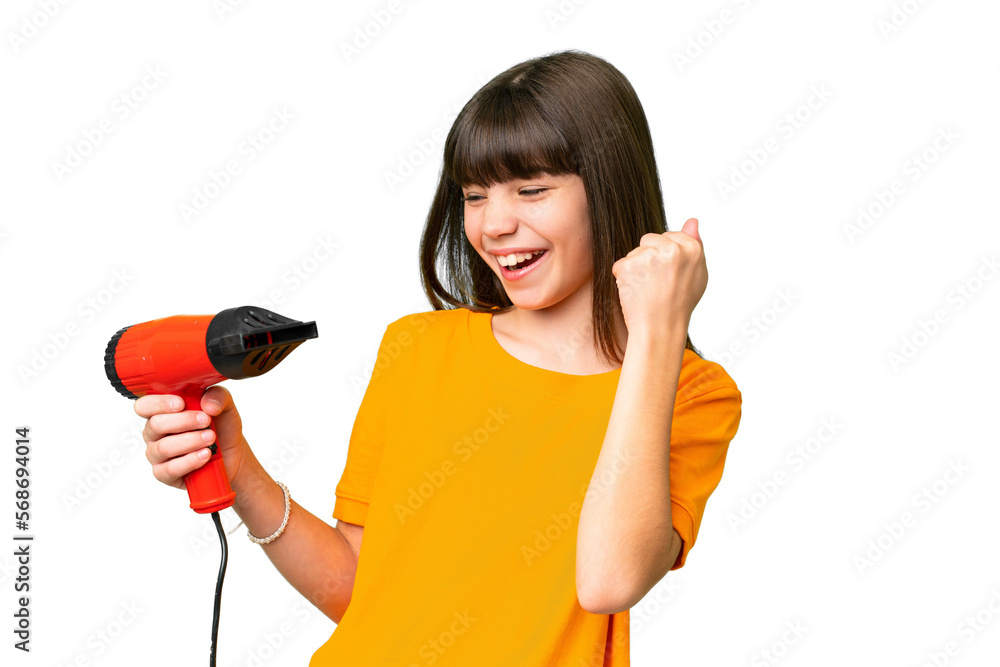 Little Caucasian girl holding a hairdryer over isolated background celebrating a victory Little Caucasian girl holding a hairdryer over isolated background celebrating a victory