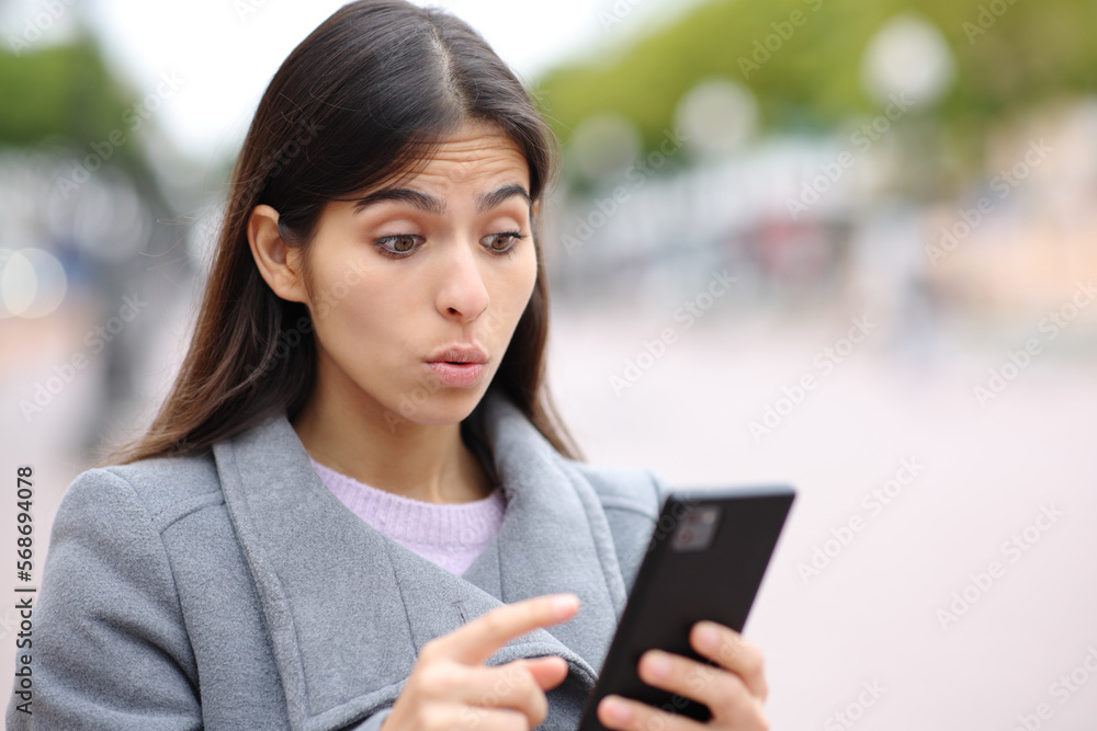 Upset woman saying oops watching phone content Upset woman saying oops watching phone content
