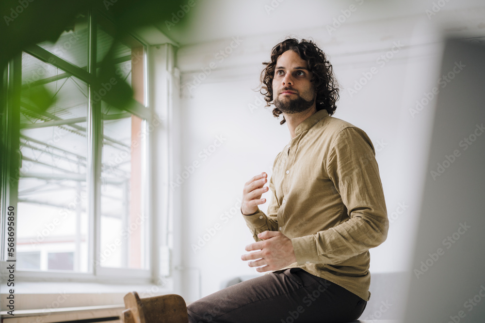 Thoughtful businessman gesturing in office Thoughtful businessman gesturing in office