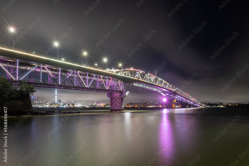 Obraz premium Auckland Harbour Bridge glowing in purple. Auckland, New Zealand
