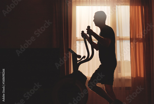 A man goes in for sports at dawn at home, silhouette photo