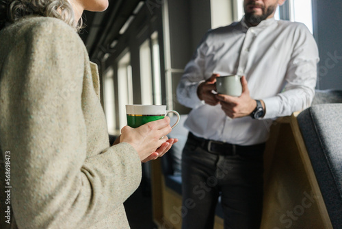 Businessman and businesswoman having a coffee break in office together photo