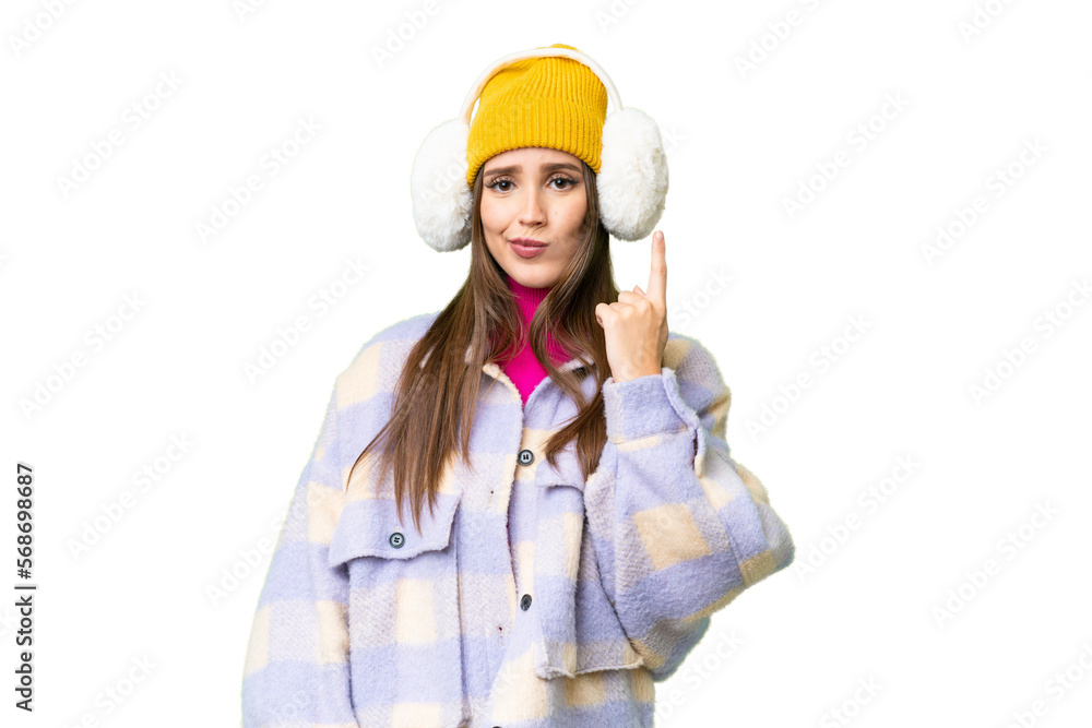 Young woman wearing winter muffs over isolated chroma key background pointing with the index finger a great idea