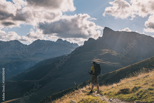 Man with a backpack hiking the mountains, Pyrenees, Spain photo