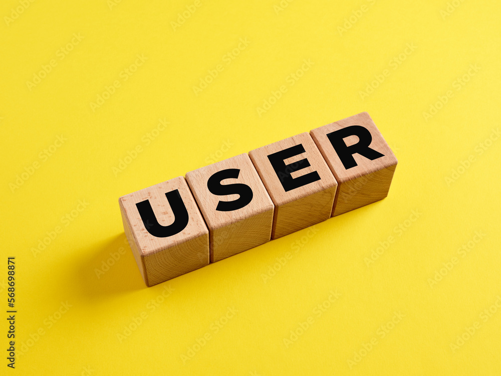 The word User on wooden cubes on yellow background. Technology concept. The word User on wooden cubes on yellow background. Technology concept.