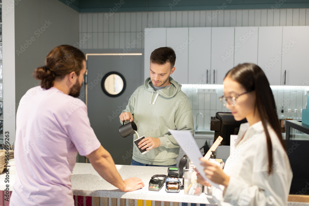 Man preparing coffee for diverse clients Man preparing coffee for diverse clients