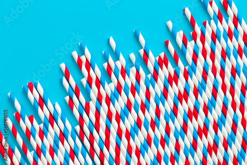 Drinking straws for party on blue background, flat lay.