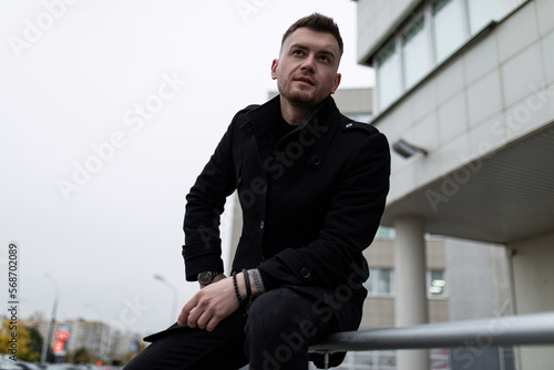 stylish brutal man defiant looking at camera outside