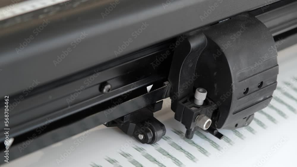 Vinyl cutter plotter machine and moving cutting head. Plotter with optical reader. Close-up of print-cut plotter head. Sticker production. Vinyl cutter plotter machine and moving cutting head. Plotter with optical reader. Close-up of print-cut plotter head. Sticker production.