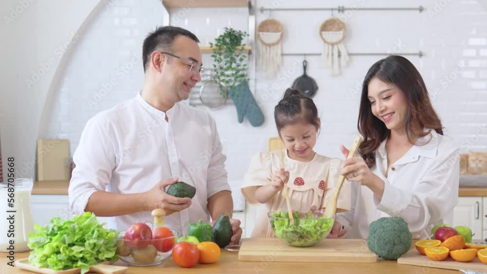 Happy parents with daughter cooking on kitchen. Smiling father , child , mother. Loving relationships and care on weekend. Happy parents with daughter cooking on kitchen. Smiling father , child , mother. Loving relationships and care on weekend.