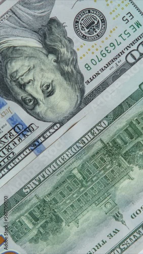 Pile of one hundred 100 dollars banknotes bills changing positions quickly. Paper banknote, money, currency savings, finance, banking payment, salary, monetary fund, business. Vertical, top view.