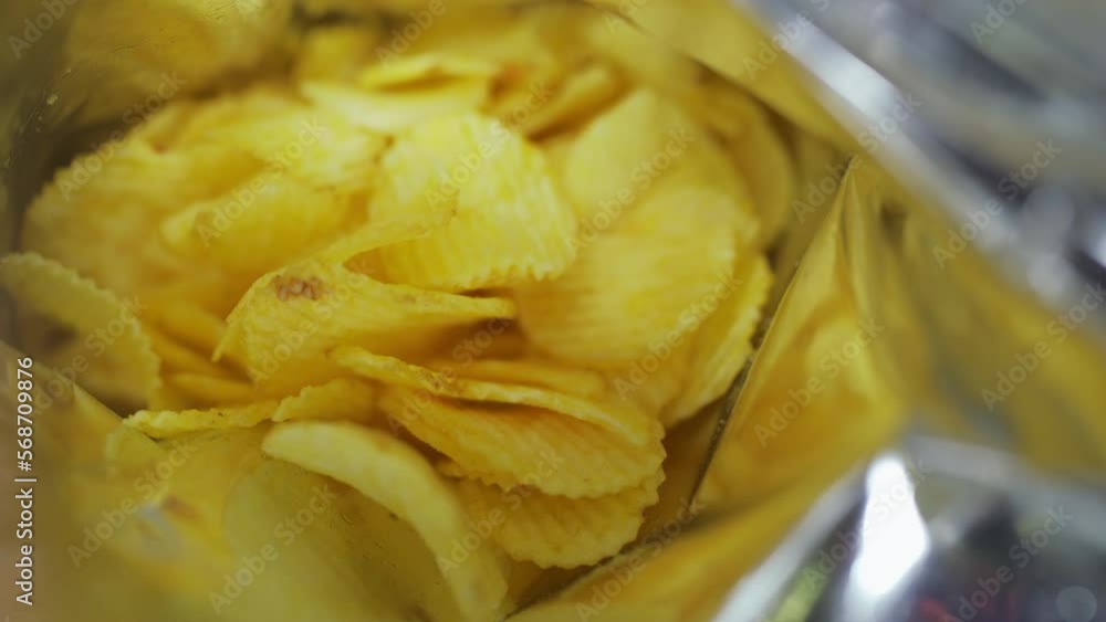 Picking potato chips from a bag with hand Picking potato chips from a bag with hand