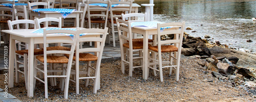 Row of White and blue greek tables and chairs in outdoor restaurant, cafe in Greece islands