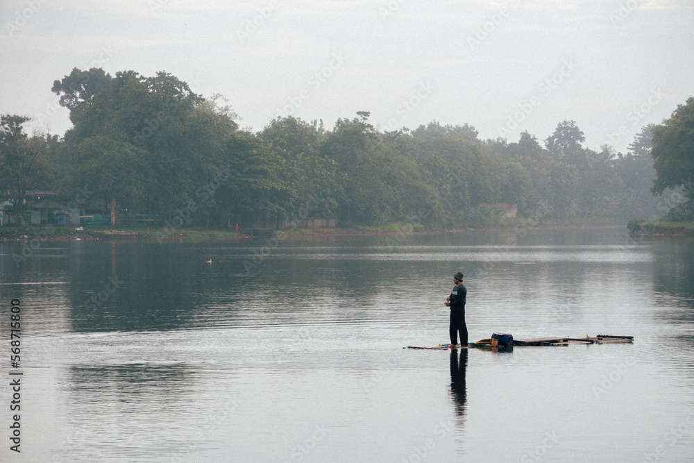 Fisherman is fishing with net on beautiful lake in the morning Fisherman is fishing with net on beautiful lake in the morning