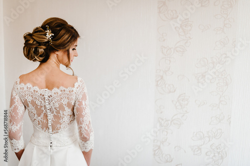Portrait of a beautiful stylish bride with an elegant hairstyle view from the back. Wedding, people, fashion and beauty concept - bride in wedding dress. Back view. photo
