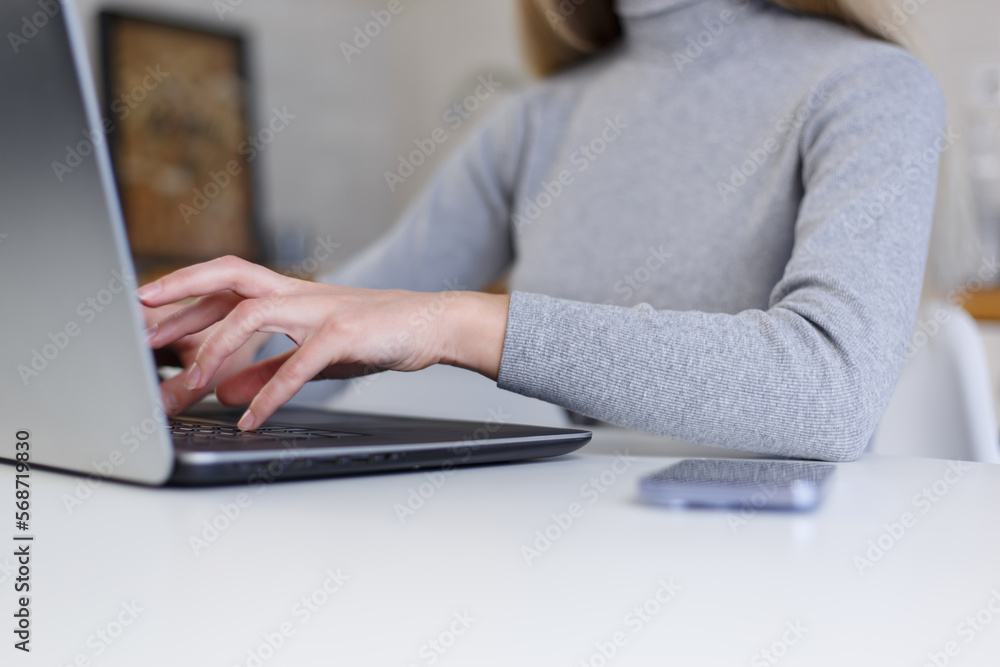 Fototapeta premium Young woman typing code on modern laptop computer at home. Female programmer person working online