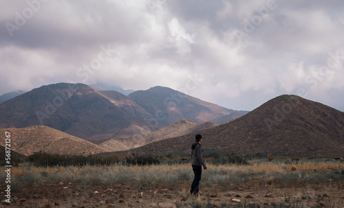 young man walking in the open field near the Andes maountain