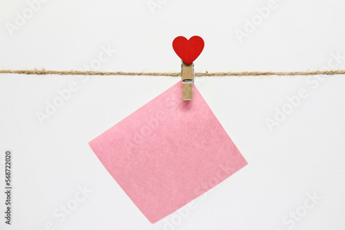 Pink note hanging for valentine's day on a thread