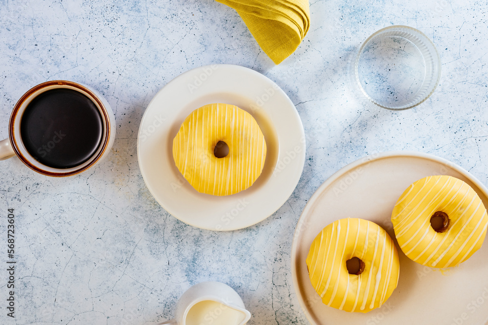 lemon doughnut in yellow glaze, coffee in a glass. lemon doughnut in yellow glaze, coffee in a glass.