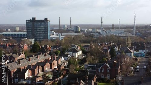 Aerial view over park trees to suburban industrial townscape with blue Pilkingtons skyscraper, Merseyside, England photo