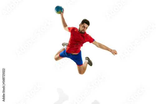 High jump. Man, professional handball player in motion, throwing ball in a jump isolated over white studio background. Concept of sport, action, motion, championship, sportive lifestyle