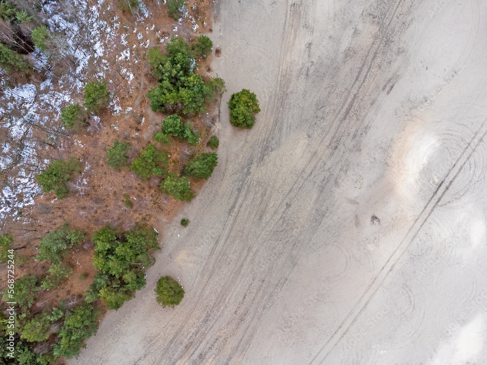Aerial view landscape. Desert seen from above, sand, trees, path.