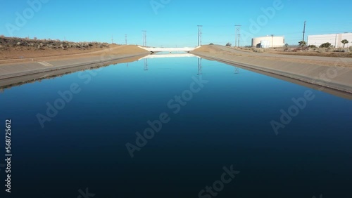 slow aerial dolly tilt of an aqueduct in hesperia california on a blue bird day in the morning photo
