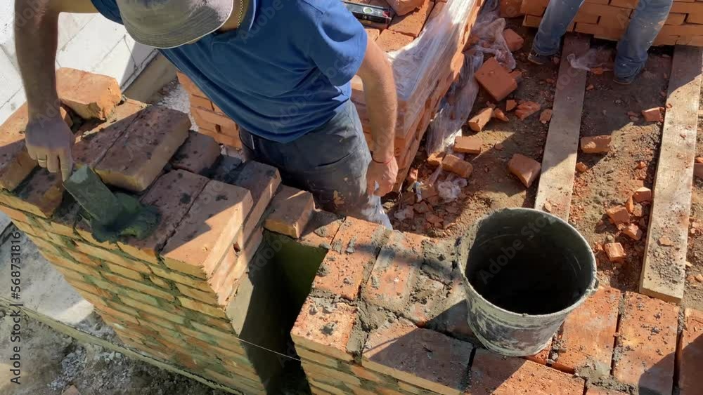 The builder performs bricklaying at the construction site. 4k video footage The builder performs bricklaying at the construction site. 4k video footage