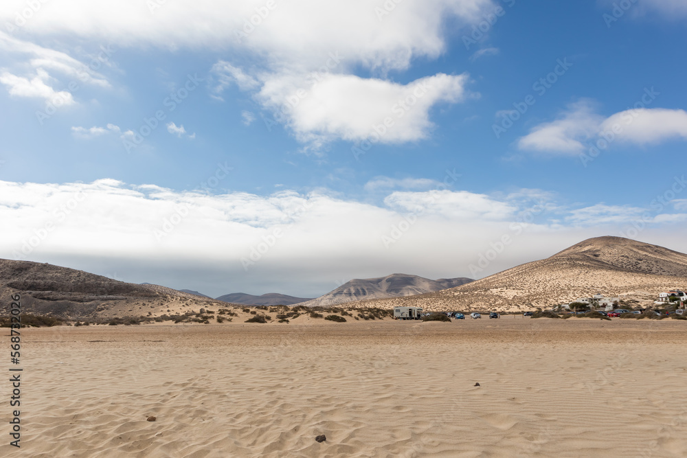 Fototapeta premium beautiful paradise beach of yellow spider in the afternoon, with large white clouds and the sea caressing the coast. Fuerteventura, Canary Islands, Spain