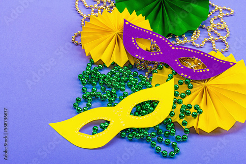 Festive Mardi Gras masquerade violet background. Fat Tuesday carnival, masks, beads, traditional decor