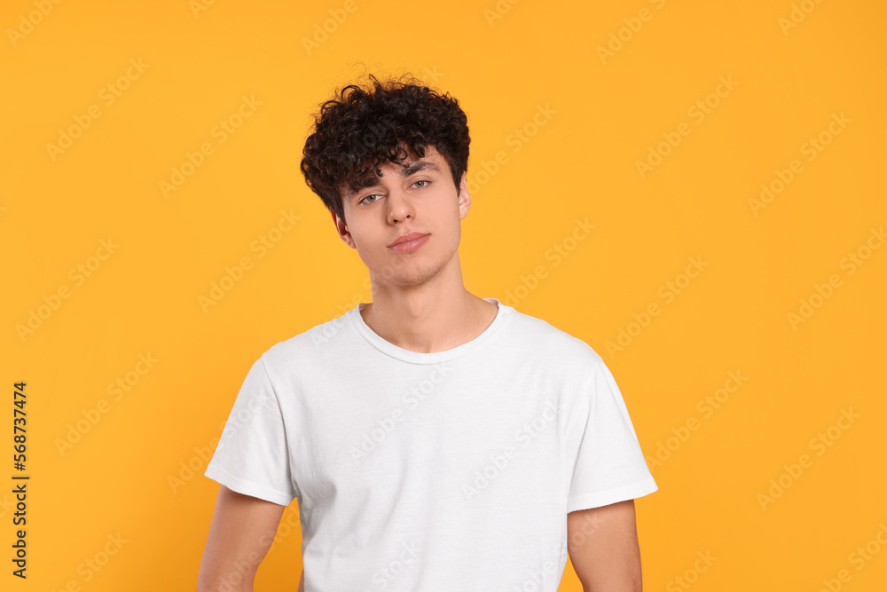 Fototapeta premium Portrait of handsome young man on orange background