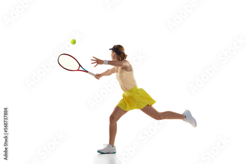 Studio shot of professional young female tennis player in sports uniform training with tennis racket isoltaed over white background. Concept of skills, sport, fashion, ad