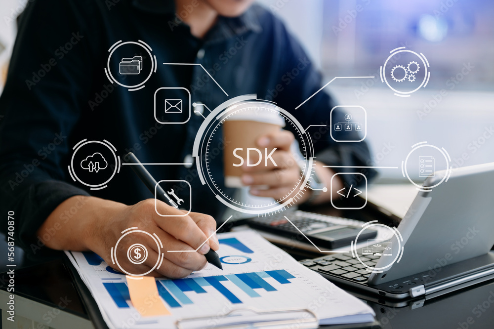 SDK Software development kit programming language technology concept,  Person typing laptop computer and tablet with SDK icon on virtual screen.  in office. Stock Photo | Adobe Stock