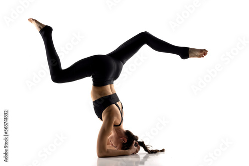 Portrait of young beautiful woman in black sportswear doing yoga practice.