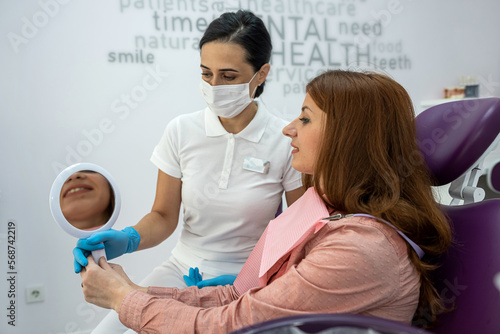 little beautiful patient sitting in dentistry with female doctor.