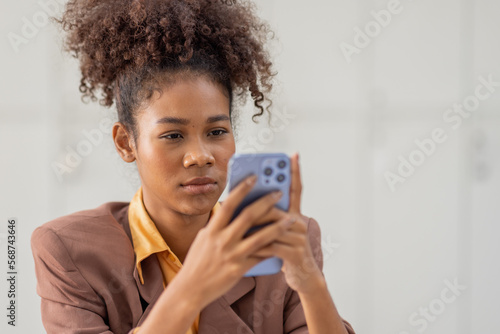 Portrait of a happy asian business african american woman using mobile phone isolated over white background