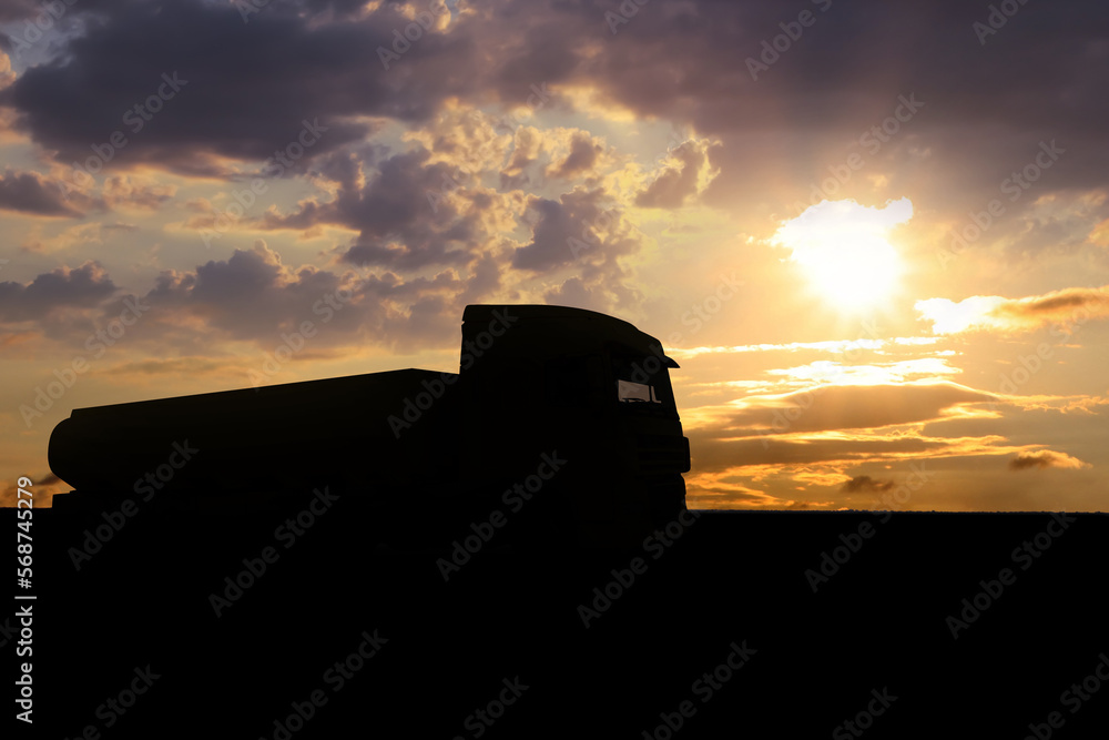 Truck parked on country road at sunset