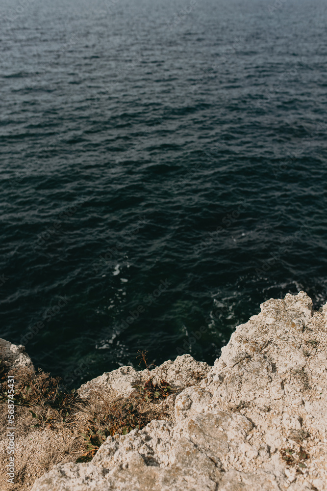 Seascape of coastline with blue water and rippled cliff or slope with descent to jump into sea, hiking while spending summer vacations in mild warm climate. Travel and adventures. Beauty of nature Seascape of coastline with blue water and rippled cliff or slope with descent to jump into sea, hiking while spending summer vacations in mild warm climate. Travel and adventures. Beauty of nature