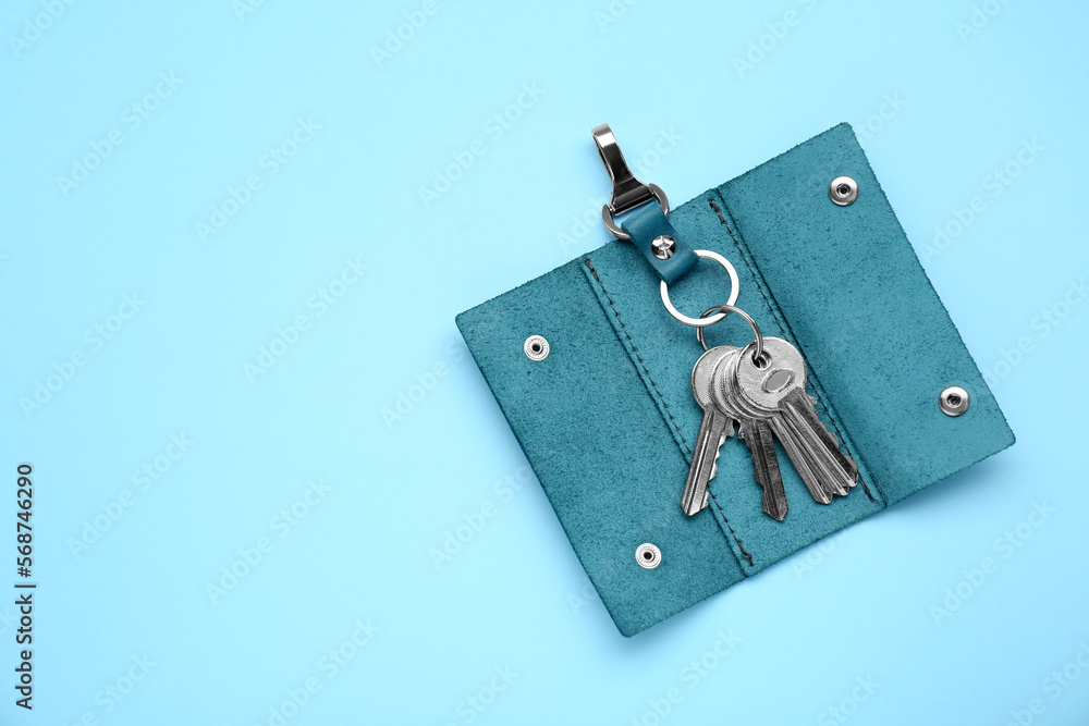 Leather holder with keys on light blue background, top view. Space for text Leather holder with keys on light blue background, top view. Space for text
