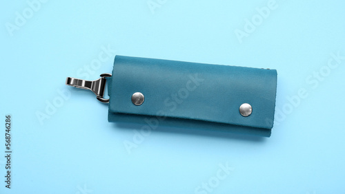 Stylish leather keys holder on light blue background, top view