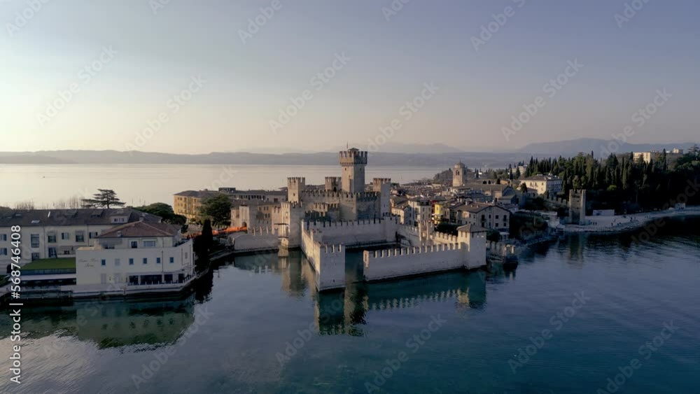 Aerial view Sirmione mediteranean historical sightseeing town in italy on lake garda. Beautiful castle on the water with historical town, sunset flight, tourism destination Aerial view Sirmione mediteranean historical sightseeing town in italy on lake garda. Beautiful castle on the water with historical town, sunset flight, tourism destination