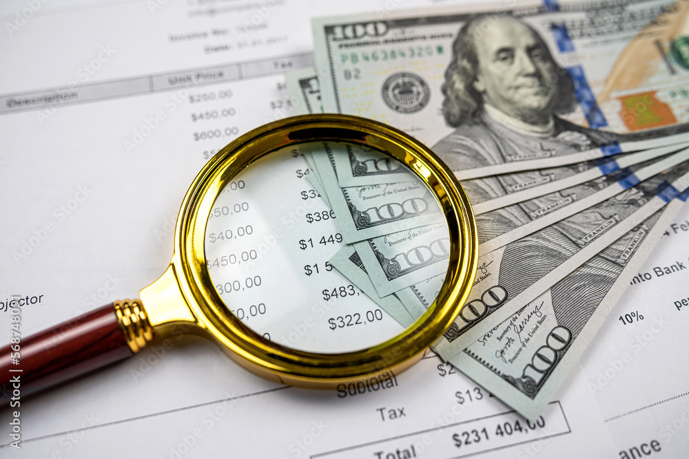 closeup of Magnifying glass dollar and pen on business charts graphs paper closeup of Magnifying glass dollar and pen on business charts graphs paper