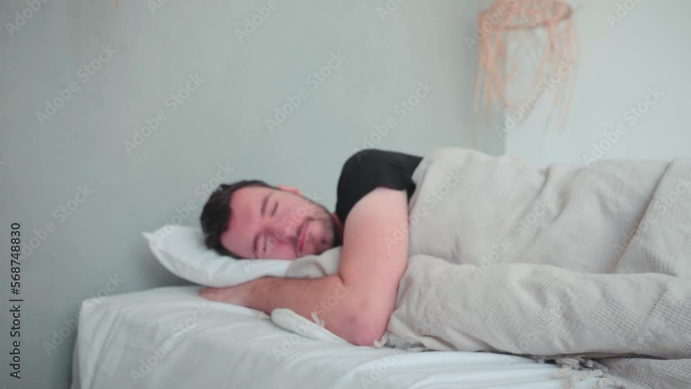 Sleeping man, caucasian white with beard, young man lying in bed sleeping dreaming, uncomfortable pillow, turn over in sleep Sleeping man, caucasian white with beard, young man lying in bed sleeping dreaming, uncomfortable pillow, turn over in sleep