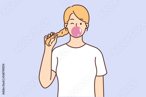 Teenage girl holds on to pigtail and blows huge bubble of fruit-flavored chewing gum