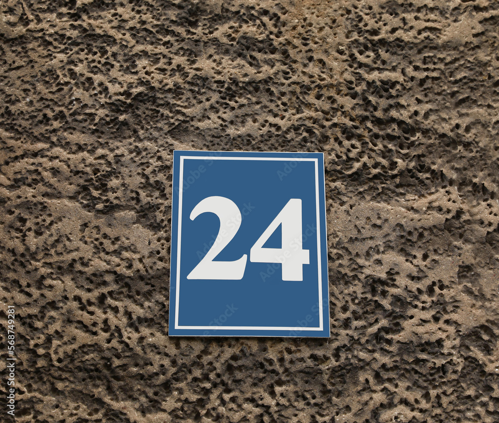 Plate with house number 24 on textured wall outdoors Plate with house number 24 on textured wall outdoors