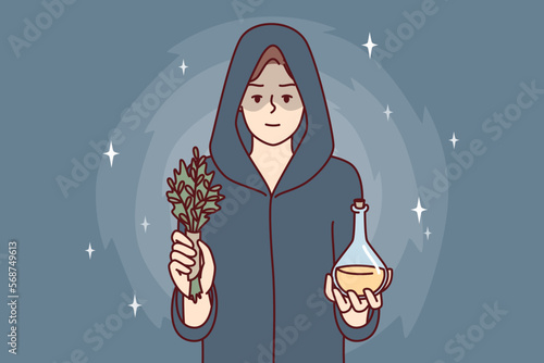 Woman sorceress dressed in cloak with hood holds miraculous elixir and sprig of plant. Healer girl prepared for mysterious rite using magic or healing conspiracy