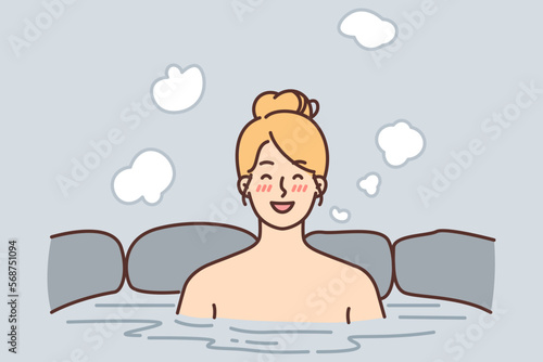Cheerful woman relish spa treatments and hot beauty bath surrounded by natural stone